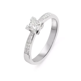  Bague sertie d un diamant taille princesse 4,2mm coté. Poids diamant central : 0,52 carat (Couleur F - Pureté Si1) Montur...