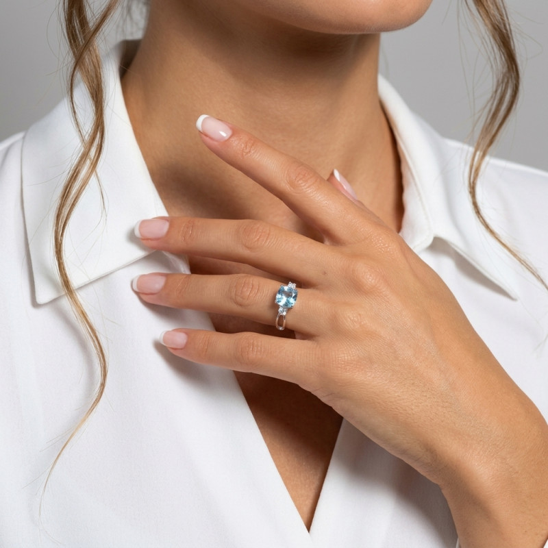Bague Argent rhodié Topaze Bleue traitée Coussin et Oxydes de zirconium porté