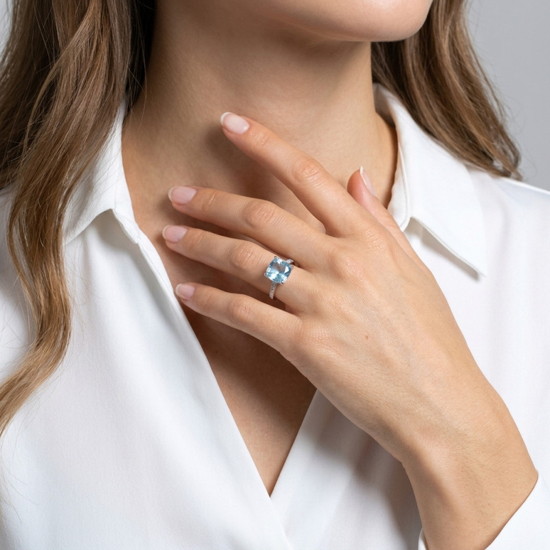 Bague Or Blanc 375 Topaze bleue traitée Coussin 10x10mm et Diamant porté