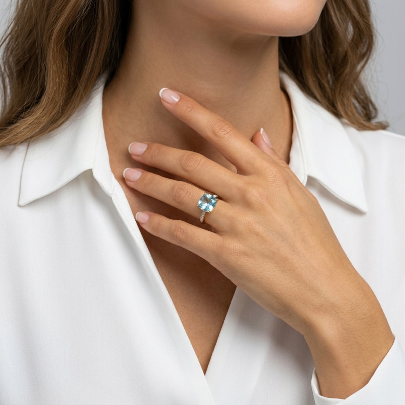 Bague Or Jaune 375 Topaze bleue traitée Coussin 10x10mm et Diamant porté