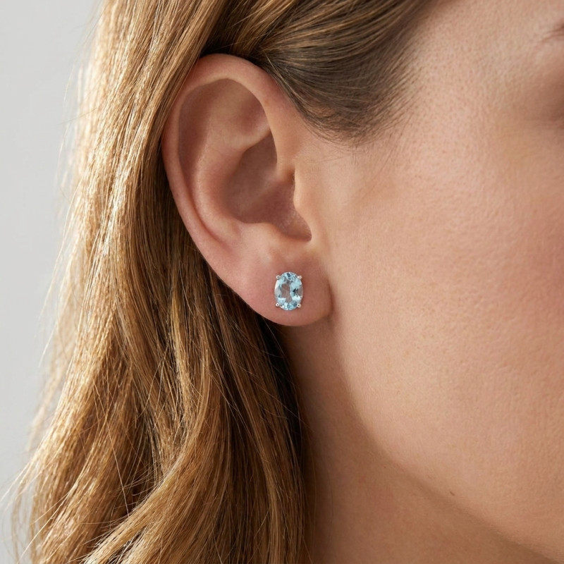 Boucles d'oreilles Or Blanc 750 Topaze bleue traitée Ovale 7x5mm porté