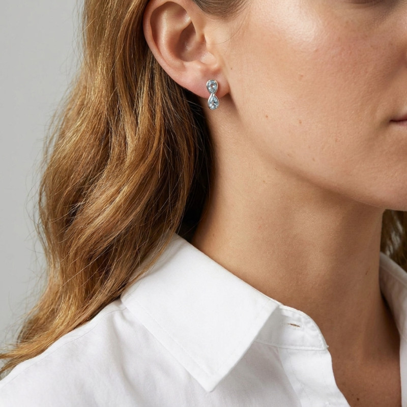 Boucles d'oreilles Signe Infini Argent 925 Rhodié et Topaze bleue traitée porté
