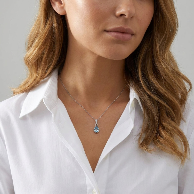 Pendentif Infini Or Blanc 375 Topaze bleue traitée Poire 8x6mm et Diamant porté