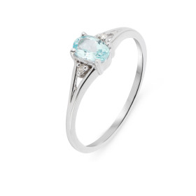 Bague Or Blanc 375 Topaze bleue traitée Ovale 6x4mm diamant Cette bague est composée : 1 Topaze bleue traitée Ovale 0.5 ca...