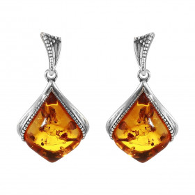 Boucles d'oreilles pendantes en argent composées d'une ambre de 11x14mm. Ambre de couleur cognac. Système d'attache : pous...